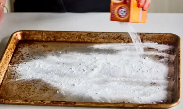 Saupoudrer du bicarbonate de soude sur une plaque de four brûlée. Une astuce pour savoir comment enlever du brûlé sur une plaque de four.