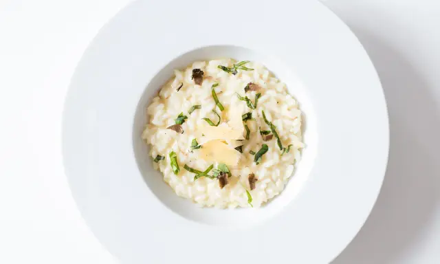 Un crémeux risotto à la truffe, parsemé de fines herbes et de copeaux de parmesan, un délice pour les sens.