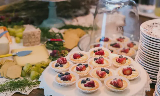 Un buffet de mariage avec des tartellettes aux fruits rouges, du fromage et des raisins. Une belle idée buffet mariage pour un événement gourmand.