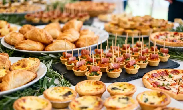 Buffet d'entrée pour un repas d'anniversaire adulte : mini-quiches, feuilletés, tartes salées, pizzas et amuse-bouches.