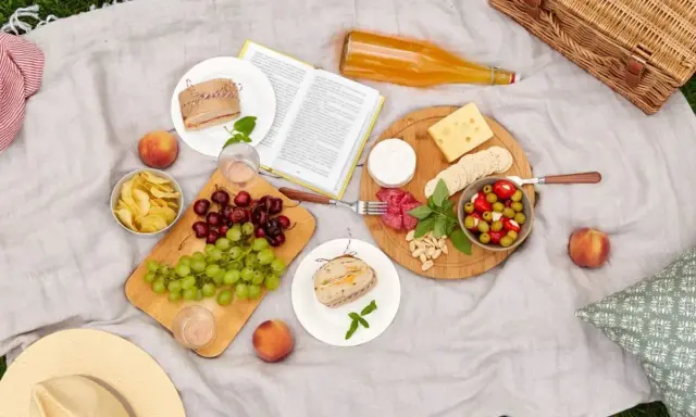 Un plateau de fromages, fruits, sandwichs et chips : voilà quoi prendre pour un picnic parfait.