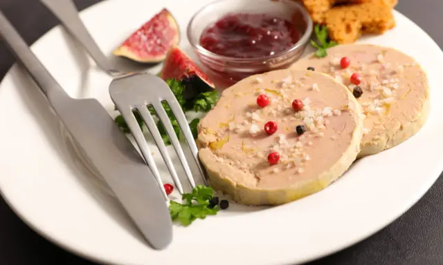 Assiette de foie gras, figues, confiture de fruits rouges et toasts. Une présentation raffinée pour un délice.