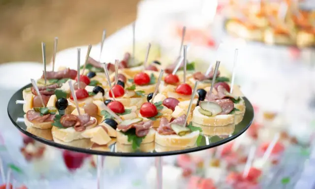 Plateau de petits fours variés, parfaits pour une idée repas baptême. Mini-brochettes avec tomates cerises, olives, charcuterie et fromage sur pain.
