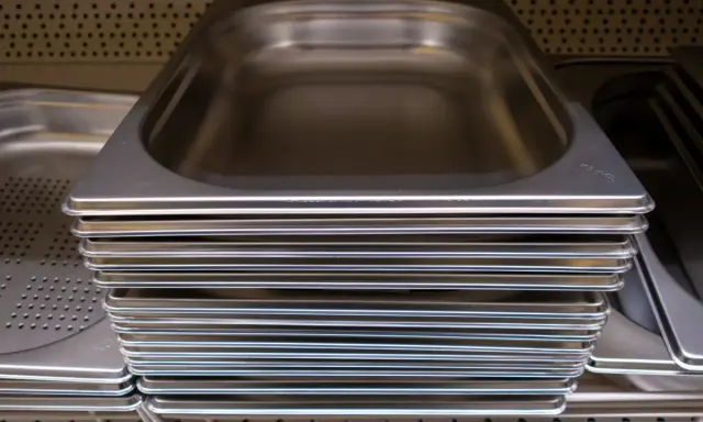Pile de bacs gastro en inox, prêts à accueillir vos préparations culinaires.