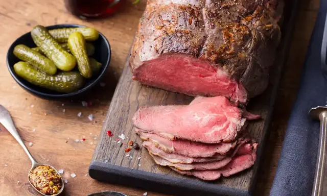 Un rôti de bœuf froid, tranché, prêt à servir pour 20 personnes. Accompagné de cornichons croquants et de moutarde à l'ancienne.