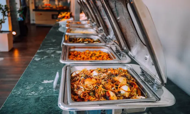 Buffet de plats chauds, idéal pour un pique-nique gourmand. Des mets variés dans des chafing dishes brillants.