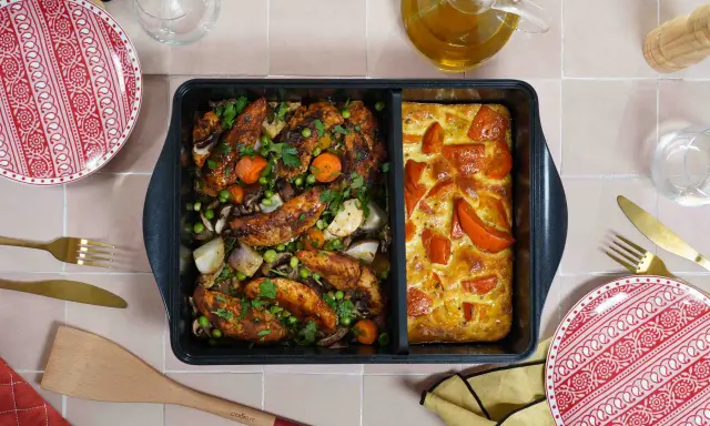 Comment savoir si un plat va au four ? Ce plat divisé présente du poulet rôti aux légumes d'un côté et un gratin de tomates de l'autre.