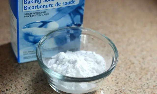 Un bol de bicarbonate de soude à côté de sa boîte. Un ingrédient polyvalent, utile pour le nettoyage et la cuisine, et même pour des expériences scientifiques impliquant de l'aluminium.