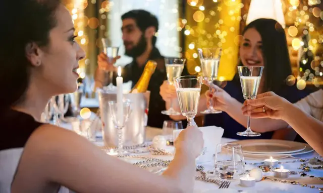 Des amis trinquant avec du champagne lors d'une fête. Une belle idée jeu du goût adulte pour animer la soirée.