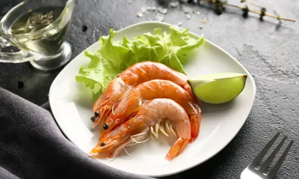 Assiette de crevettes avec laitue et citron vert. Une question se pose : combien de crevettes par personne pour ce délice ?