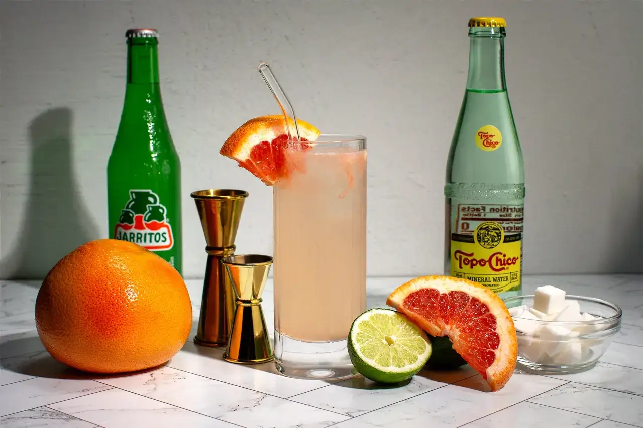 Ingrédients pour une recette de cocktail Paloma : pamplemousse, citron vert, sucre, Jarritos et Topo Chico.