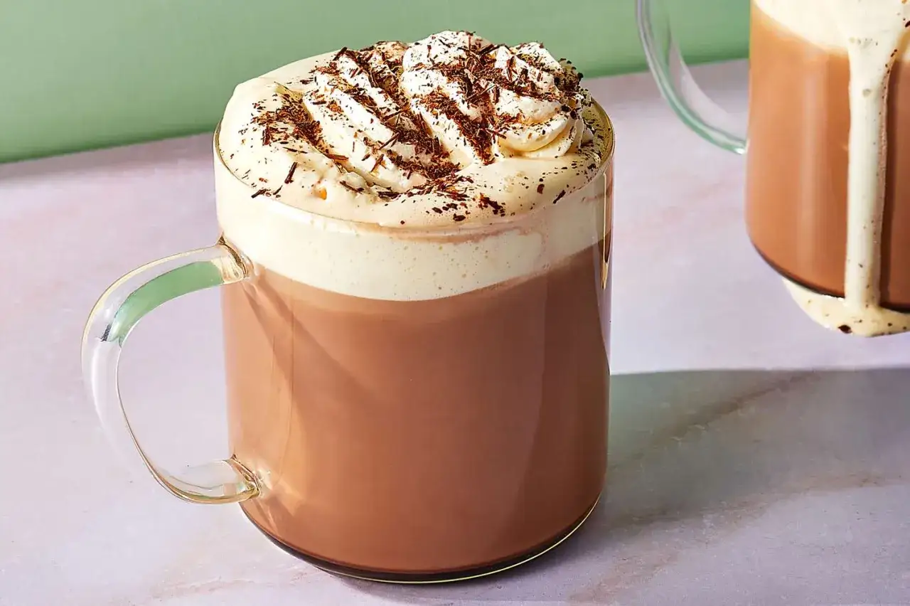 Un délicieux moka chocolat, surmonté de crème fouettée et de copeaux de chocolat, prêt à être dégusté.
