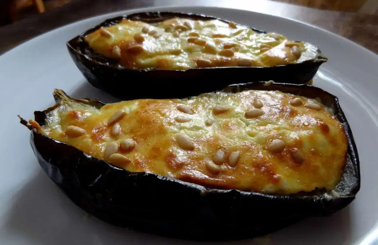 Aubergines farcies au fromage feta, une d&eacute;licieuse recette grecque, garnies de pignons de pin grill&eacute;s.