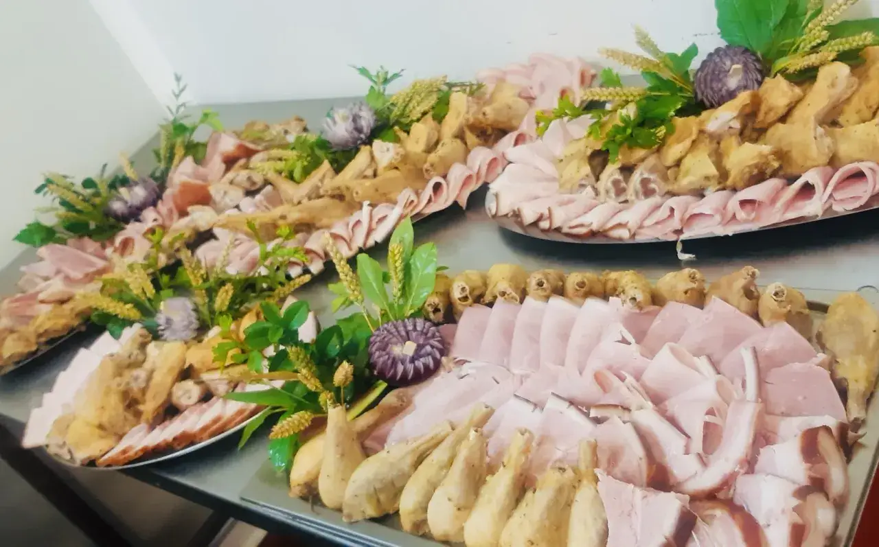 Plateaux de charcuterie et de poulet froid, parfaits pour une recette poulet froid pour buffet. Décorés de verdures et de fleurs comestibles.