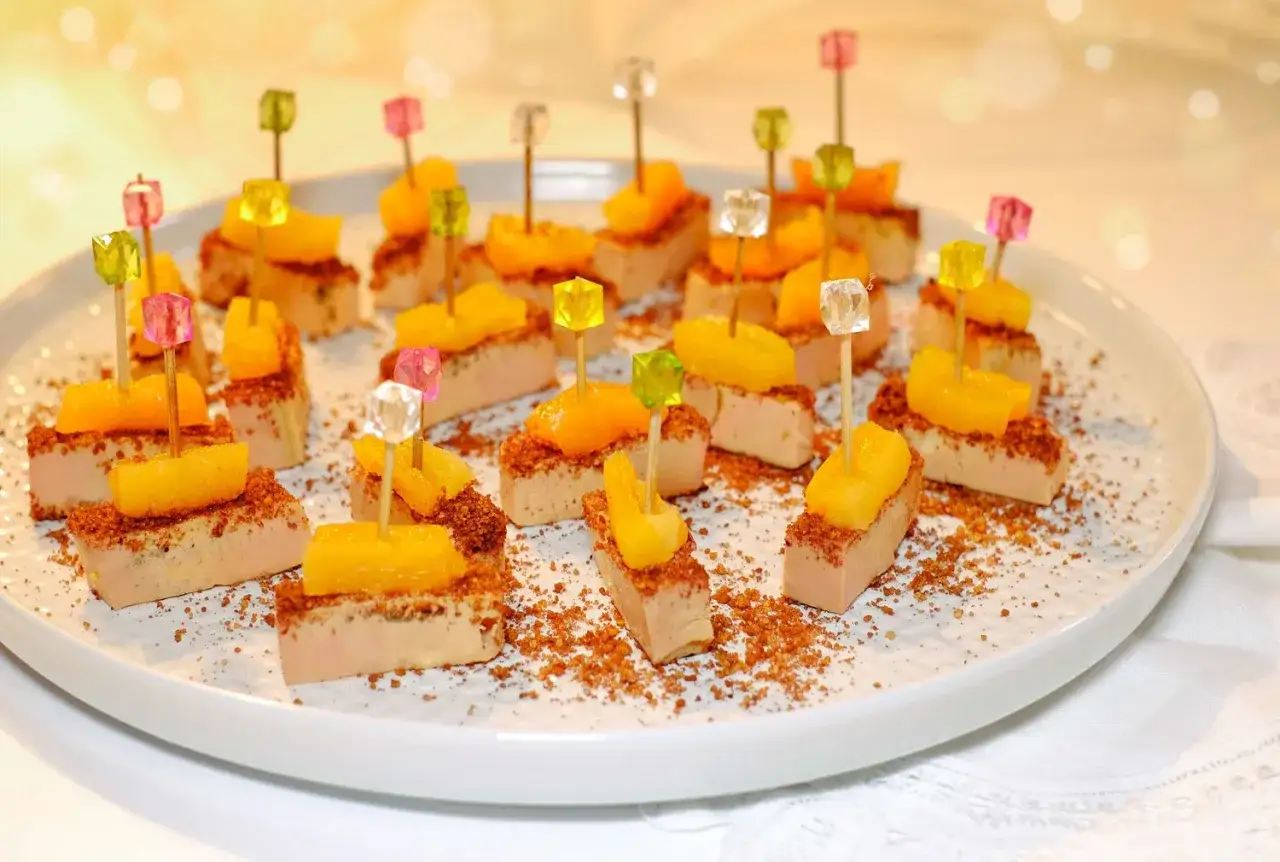 Des bouchées de foie gras surmontées de fruits et décorées de broyés, une façon originale de servir ce délice.