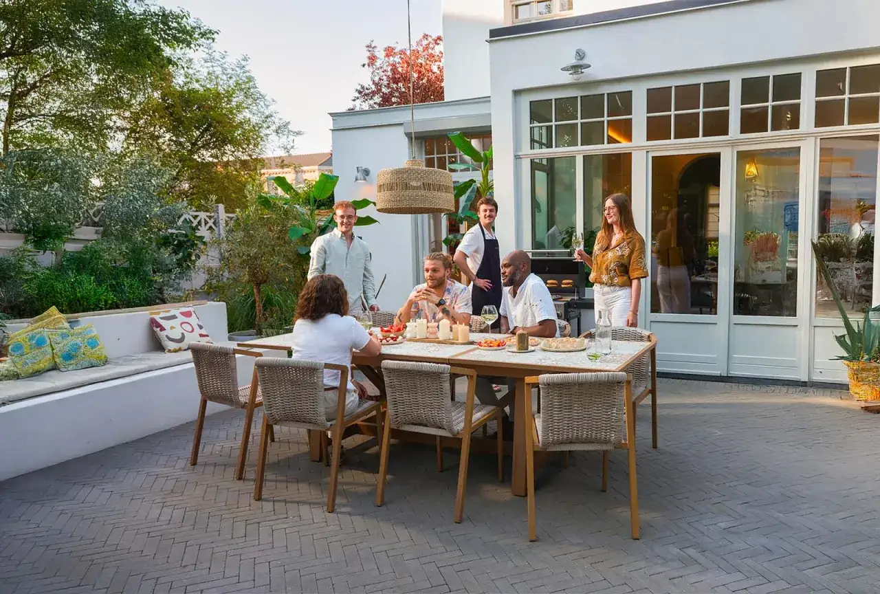 Un joyeux cousinade repas en terrasse, avec des amis partageant un barbecue et des rires autour d'une grande table.