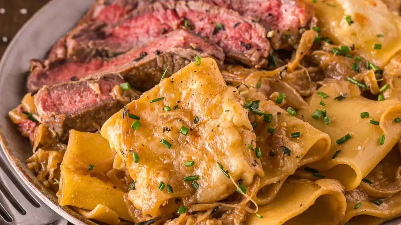Tranches de b&oelig;uf saignant servies avec des p&acirc;tes larges napp&eacute;es d'une sauce cr&eacute;meuse et garnies de ciboulette. Un d&eacute;lice qui rappelle la sauce anglaise.