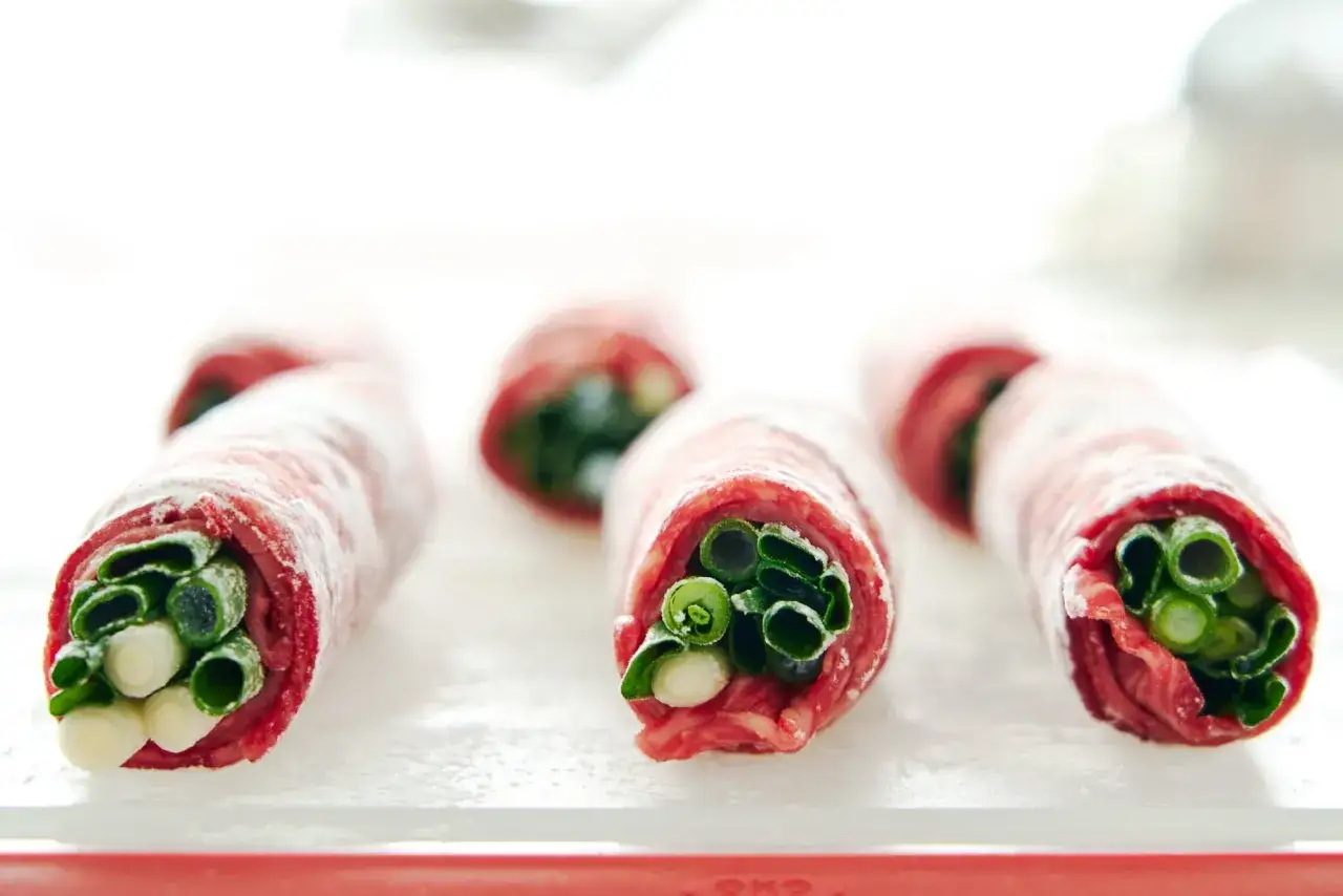 Rouleaux de boeuf et oignons verts, pr&ecirc;ts &agrave; &ecirc;tre cuisin&eacute;s. Un d&eacute;lice qui rappelle le boeuf fromage.