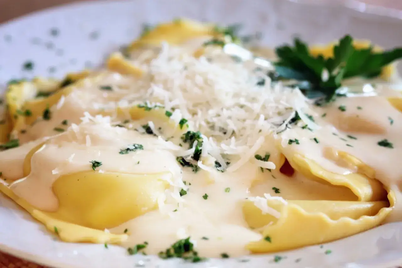 Raviolis dor&eacute;s napp&eacute;s d'une sauce cr&eacute;meuse, parsem&eacute;s de parmesan r&acirc;p&eacute; et de persil frais. Un d&eacute;lice de ravioli truffe.