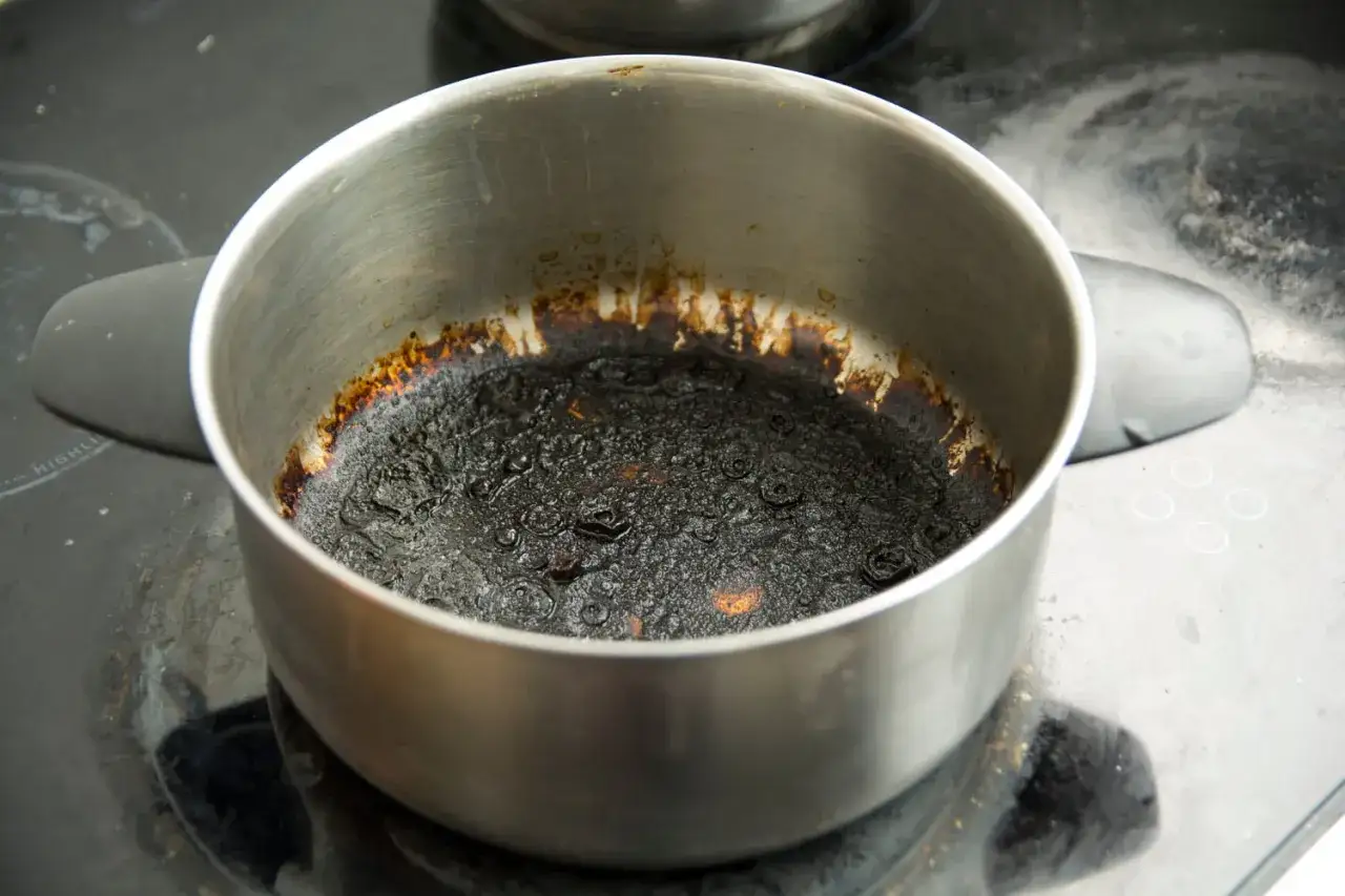 Casserole brûlée, un cauchemar pour savoir comment enlever du caramel. Des résidus noirs et collants recouvrent le fond.