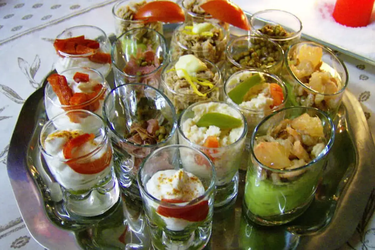 Plateau de salades originales pour buffet : verrines colorées et variées, garnies de légumes, fruits, et sauces crémeuses.