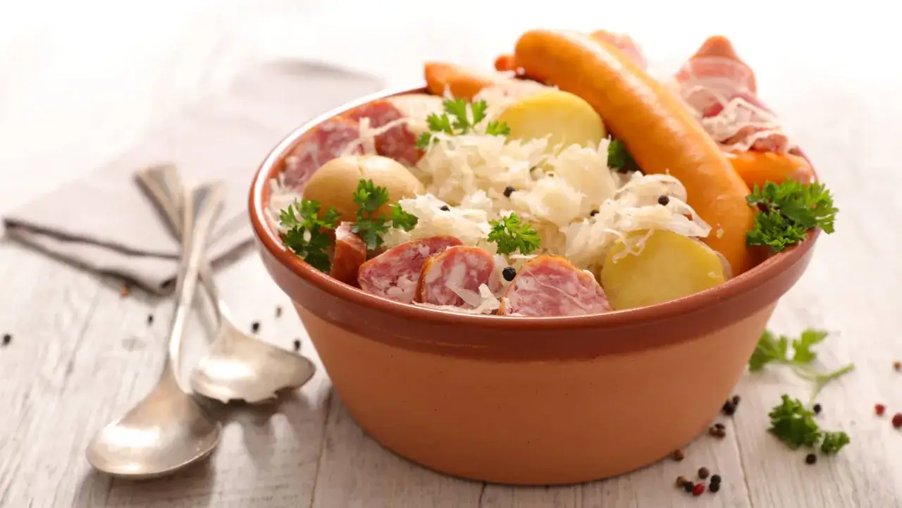 Un plat g&eacute;n&eacute;reux d'une authentique entr&eacute;e alsacienne : choucroute, saucisses, pommes de terre et lard, garni de persil frais.