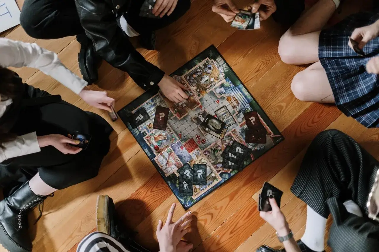 Groupe d'amis jouant à un jeu de société, une excellente idée jeu du goût adulte pour une soirée.