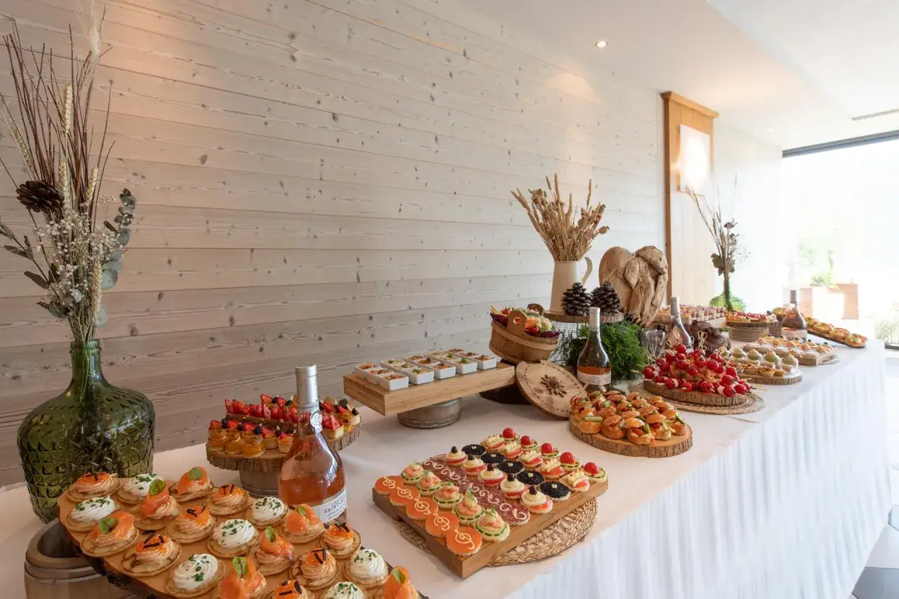 Buffet de brunch mariage : assortiment de mini-sandwichs, tartines saumon, brochettes de tomates cerises et petits fours sucrés.