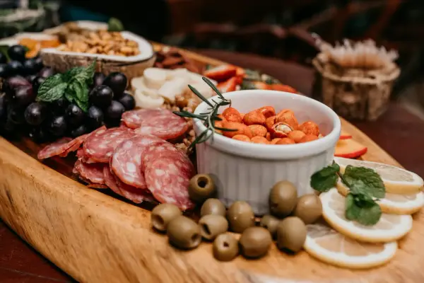 Plateau gourmand avec raisins, saucisson, olives, cacahuètes épicées et fruits. Un vrai menu campagnard !