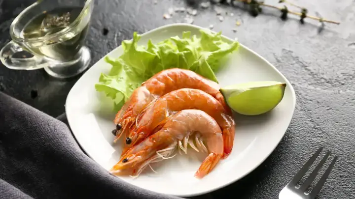Assiette de crevettes avec laitue et citron vert. Une question se pose : combien de crevettes par personne pour ce délice ?